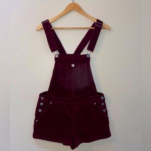 Adjustable maroon overall shorts.